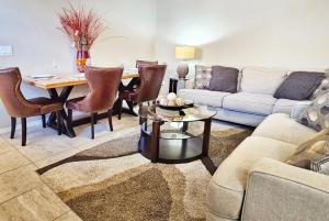 a living room with a couch and a table at Spacious Desert Suite Minutes to Phoenix Fun - Pet Friendly! in Avondale