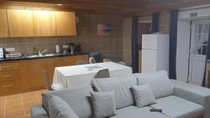 a living room with a couch and a kitchen at Casa do Avô Almeida in Lajes das Flores