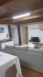 a living room with white couches in a room at Casa do Avô Almeida in Lajes das Flores