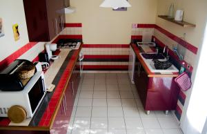 a small kitchen with red and white stripes at Gite Le Calcadis in Mostuéjouls +10 photos