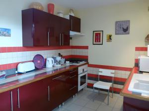 a kitchen with red and white tiles on the wall at Gite Le Calcadis in Mostuéjouls