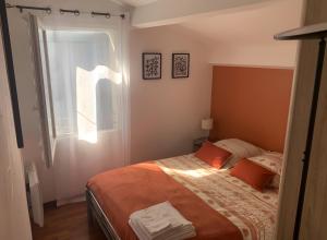 a bedroom with a bed and a window at Gite Le Calcadis in Mostuéjouls