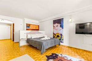 a bedroom with a bed and a flat screen tv at Unique Apartahotel 3-3 in Torrevieja