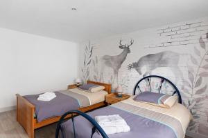 a bedroom with two beds and a wall with a deer mural at Gîte Du Centre avec terrasse in Romorantin