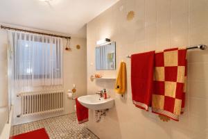 a bathroom with a sink and a shower with red towels at Haus Schindler in Ottenhöfen +20 photos