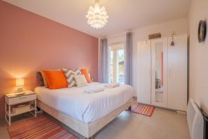 a bedroom with a large bed and a chandelier at Villa M Vallon Pont d'arc in Vallon-Pont-dʼArc