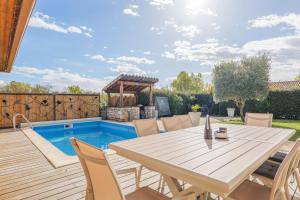 a patio with a table and chairs next to a pool at Villa M Vallon Pont d'arc in Vallon-Pont-dʼArc