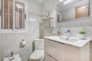 a white bathroom with a toilet and a sink at Brooklyn in Oliva +17 photos