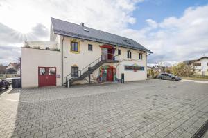 a white building with a staircase in a parking lot at Fewo Mit Herz Und Holz Penzing in Penzing