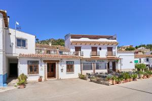 a white building with a store on a street at Villa Carlitos in Comares