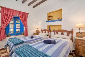 two beds in a bedroom with red curtains at Villa Carlitos in Comares +32 photos
