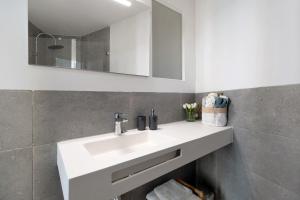 a bathroom with a white sink and a mirror at Casa Milano 1 in Jerez de la Frontera