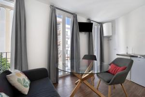 a living room with a glass table and two chairs at Casa Milano 1 in Jerez de la Frontera