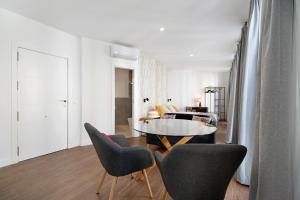 a living room with a glass table and chairs at Casa Milano 1 in Jerez de la Frontera +21 photos