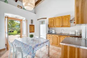 a kitchen with a table with chairs and a refrigerator at Es Camp Pla in Sineu +13 photos