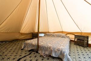 a bedroom with a bed in a tent at Tente Glamping Éco-Chic in Auriac-du-Périgord