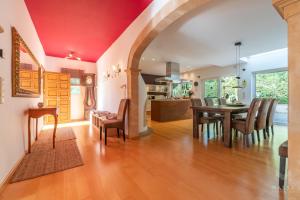 a dining room and living room with a table and chairs at Finca Assindia, Costa de los Pinos in Son Servera