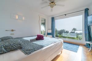 a bedroom with a bed and a large window at Finca Assindia, Costa de los Pinos in Son Servera +30 photos
