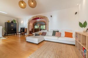 a living room with a white couch and a table at Finca Assindia, Costa de los Pinos in Son Servera