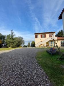 a house with a gravel driveway in front of it at Podere Sasso 3 in San Gimignano