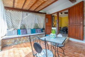 a patio with a couch and a table and chairs at Casa Fiamma in Stintino