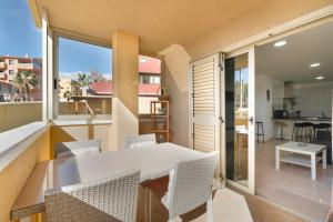 a dining room with a white table and chairs on a balcony at Sandra La Perla in El Médano