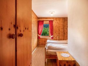 a small room with a bed and a window at Ciasa Lino Sas da le Undesc in Pozza di Fassa