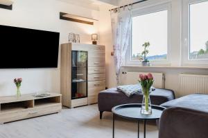 a living room with a tv and a couch and a table at Grünes Tal - Seenah in Stockach