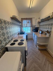 a kitchen with a stove top oven in a room at Central location location in Hollington