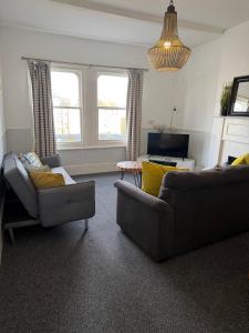 a living room with two couches and a television at Central location location in Hollington