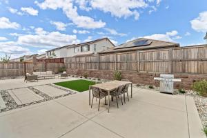 a patio with a table and chairs and a fence at Monthly or Daily Stay in Spacious 4BD for Family or Work with Outdoor backyard and BBQ grill in Folsom