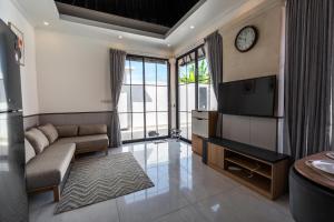 a living room with a couch and a tv at Blue Marlin Villas Legian in Legian