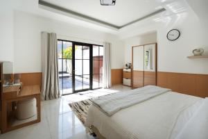a bedroom with a bed and a desk and a window at Blue Marlin Villas Legian in Legian +39 photos