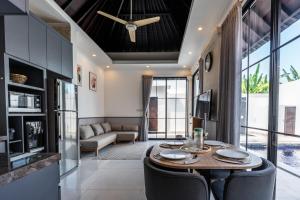 a living room with a table and chairs and a couch at Blue Marlin Villas Legian in Legian