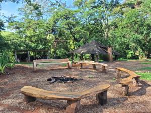 a group of benches and a picnic table with a fire at Fazenda São Leandro in Rio das Flores