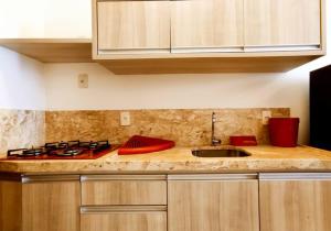 a kitchen counter with a sink and a stove at Hotel Natal Ponta Negra Sun in Natal
