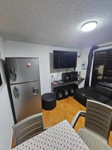 a living room with a refrigerator and a tv at Departamento central Lg in Pereira