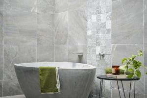 a bath tub in a bathroom with a green towel at Secluded rainforest getaway in Currumbin Valley