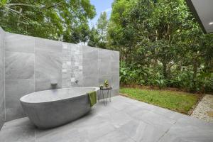 a bath tub sitting on a patio with trees at Secluded rainforest getaway in Currumbin Valley