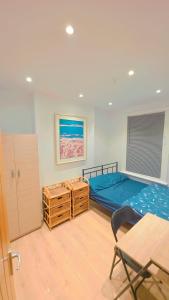 a bedroom with a blue bed and a table and chairs at Legoland Room in Bearsted