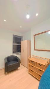 a bedroom with a bed and a chair and a mirror at Legoland Room in Bearsted