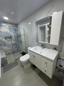 a white bathroom with a toilet and a sink at HOTEl LIRIOS DEL MAR in Santo Domingo