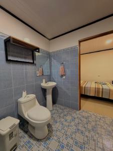 a bathroom with a toilet and a sink and a bed at Casa Osa Azul in Puerto Jiménez