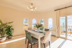 a dining room with a table and chairs and windows at Macondo Altea Hills in Altea