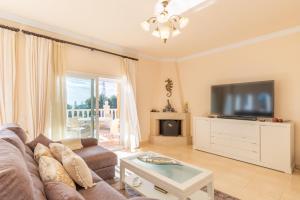 a living room with a couch and a flat screen tv at Macondo Altea Hills in Altea