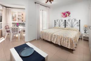 a bedroom with a bed and a table and a dining room at Estudio Bloque 89 in Torrox +17 photos