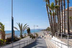 a sidewalk next to the beach with palm trees at Estudio Bloque 89 in Torrox