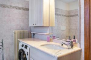a bathroom with a sink and a washing machine at Appartamento Cles in Cles +18 photos