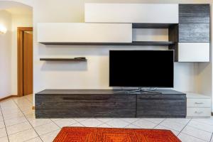 a flat screen tv sitting on top of a wooden entertainment center at Appartamento Cles in Cles