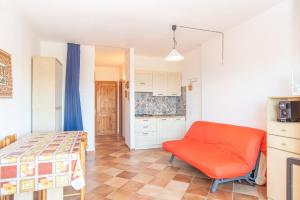 a bedroom with a bed and a orange chair at Flat Orizzonte in Palau +17 photos